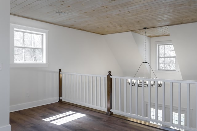 spare room with baseboards, wood ceiling, an inviting chandelier, and wood finished floors