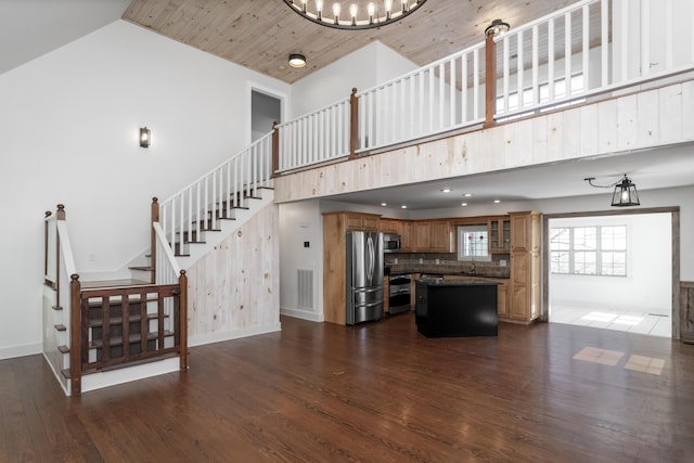 living room with dark wood finished floors, visible vents, high vaulted ceiling, and baseboards