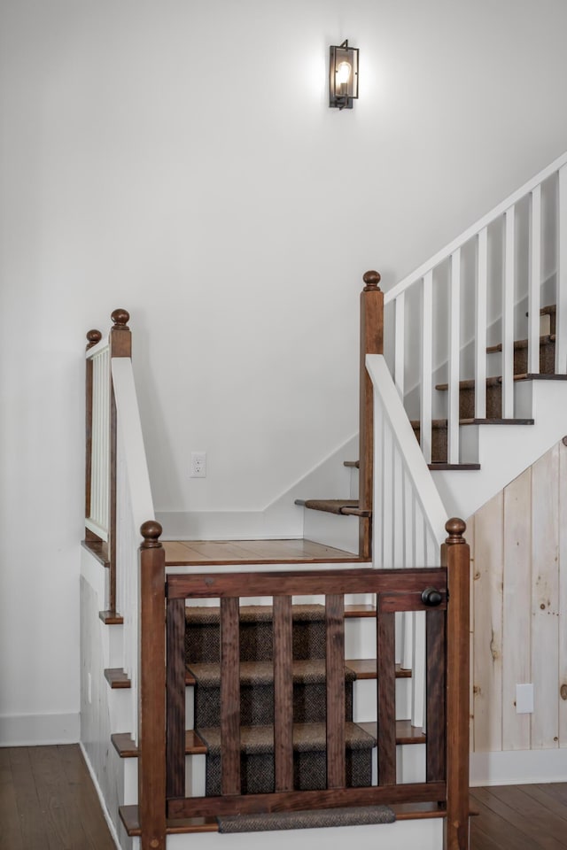 stairway with baseboards and wood finished floors