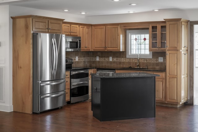 kitchen with a center island, dark wood-style flooring, stainless steel appliances, and a sink