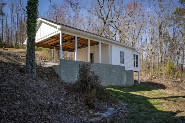 view of side of home with board and batten siding and a yard