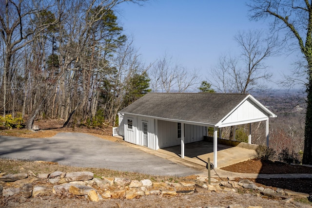 view of outdoor structure with a carport and aphalt driveway