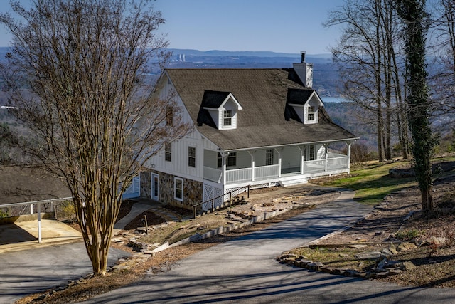 view of front of property with a porch, a carport, a chimney, and aphalt driveway