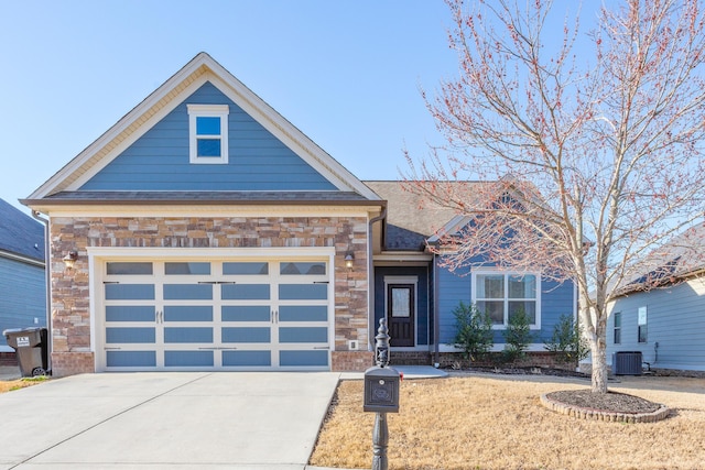 view of front of house featuring stone siding, concrete driveway, and an attached garage