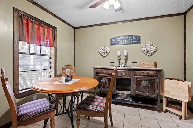 dining area with light tile patterned floors, a textured ceiling, a ceiling fan, and crown molding