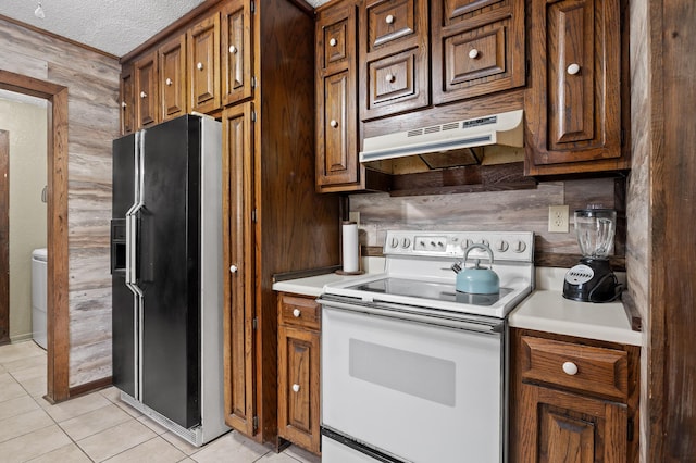 kitchen featuring light tile patterned flooring, under cabinet range hood, white electric range, light countertops, and black fridge