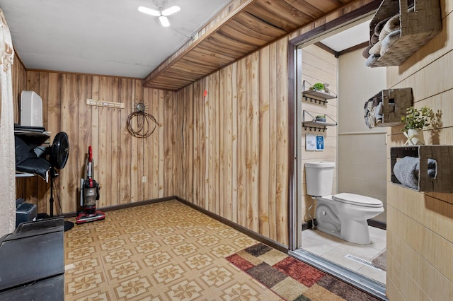 interior space featuring baseboards, light floors, and wooden walls