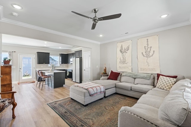 living room featuring ceiling fan, recessed lighting, light wood-style flooring, and crown molding