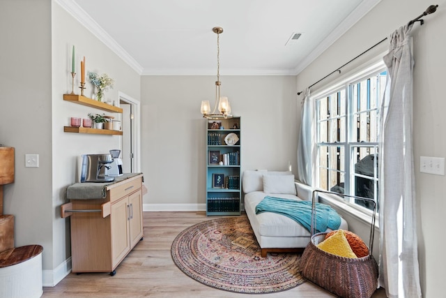 sitting room with an inviting chandelier, light wood-style flooring, baseboards, and crown molding