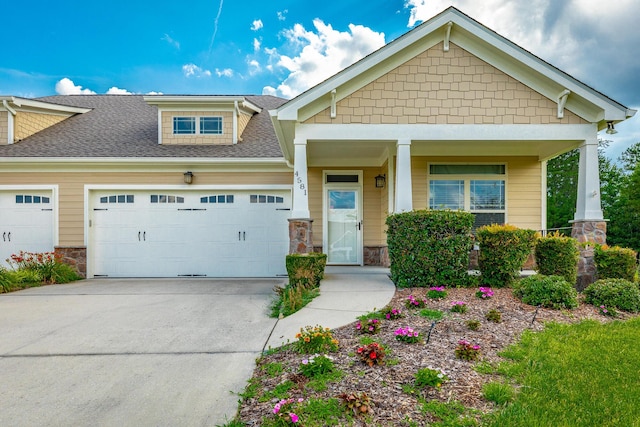 4581 Sweet Berry Ln, Ooltewah, TN 37363 - craftsman house featuring an attached garage, roof with shingles, concrete driveway, stone siding, and covered porch