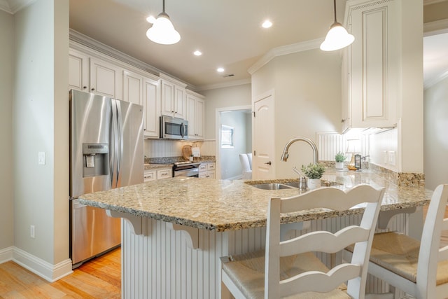 4581 Sweet Berry Ln, Ooltewah, TN 37363 - kitchen featuring stainless steel appliances, ornamental molding, light wood-style floors, a peninsula, and recessed lighting