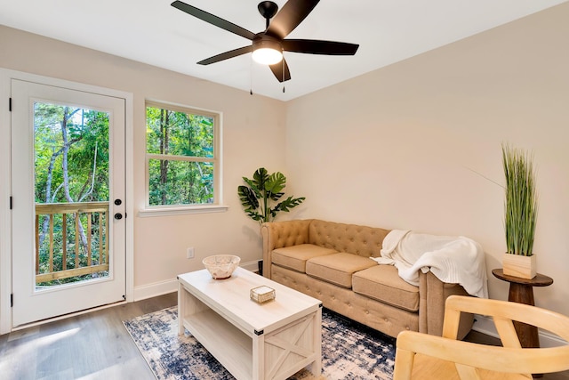 living room featuring ceiling fan, baseboards, and wood finished floors