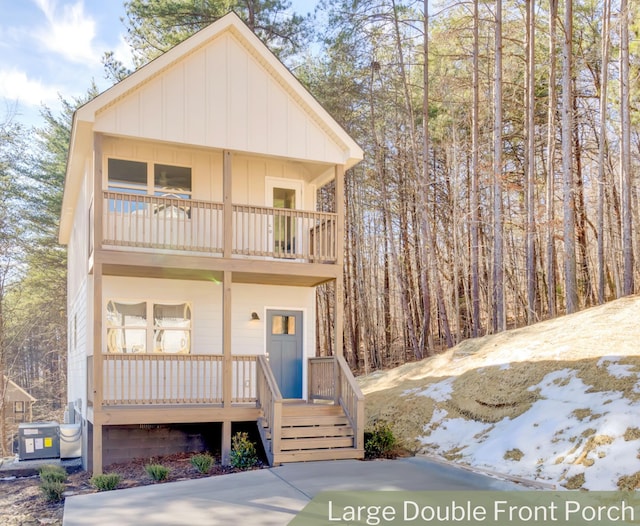 view of front of property with covered porch, central AC, and a balcony