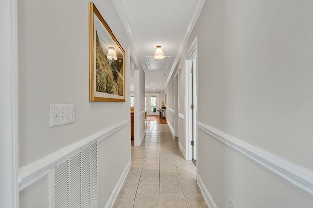 corridor featuring light tile patterned floors, visible vents, and ornamental molding