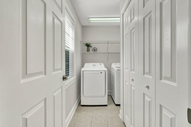 laundry area with light tile patterned floors, laundry area, baseboards, and separate washer and dryer