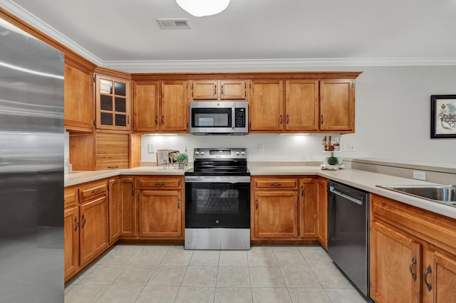 kitchen featuring light tile patterned floors, brown cabinetry, visible vents, and appliances with stainless steel finishes