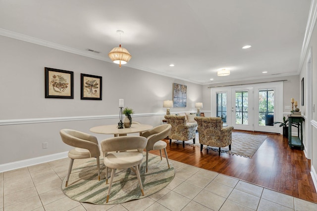 dining room with visible vents, baseboards, light tile patterned flooring, and crown molding