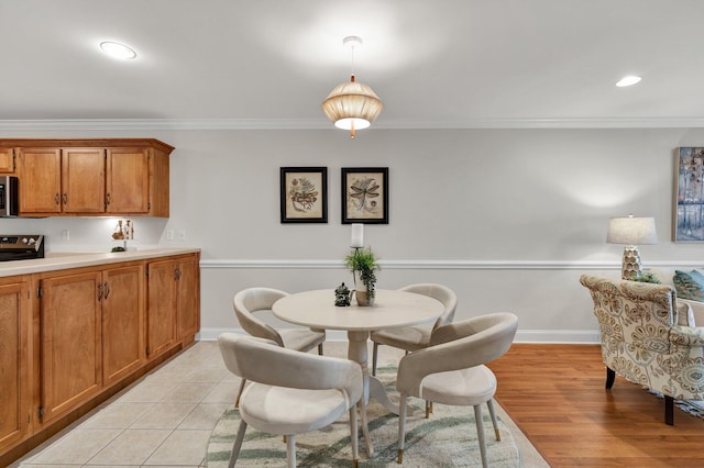 dining area featuring crown molding, light wood-style flooring, recessed lighting, and baseboards