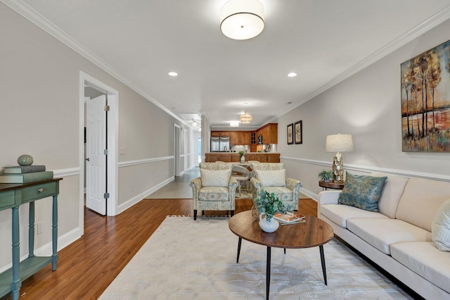 living area featuring crown molding, baseboards, and wood finished floors