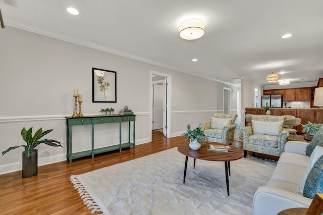 living area featuring recessed lighting, baseboards, light wood-style floors, and crown molding