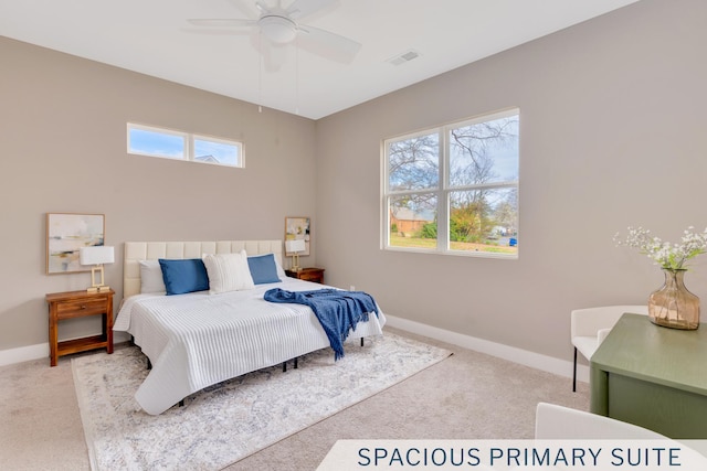 carpeted bedroom featuring multiple windows, baseboards, visible vents, and ceiling fan