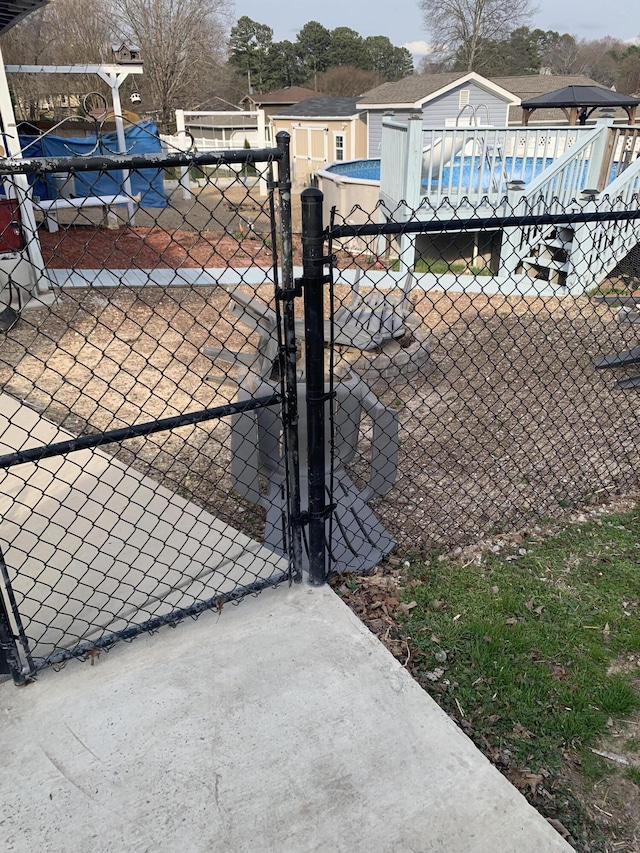 view of gate featuring fence and an outdoor pool