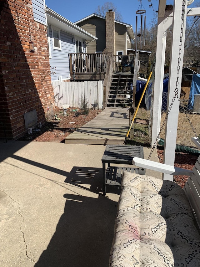 view of patio / terrace with stairway, a wooden deck, and fence