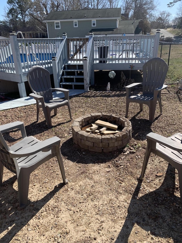 exterior space with a wooden deck, a fire pit, and a pool