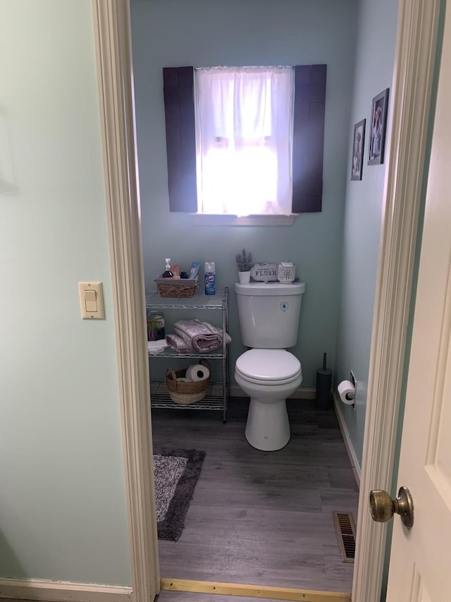 bathroom featuring visible vents, toilet, baseboards, and wood finished floors