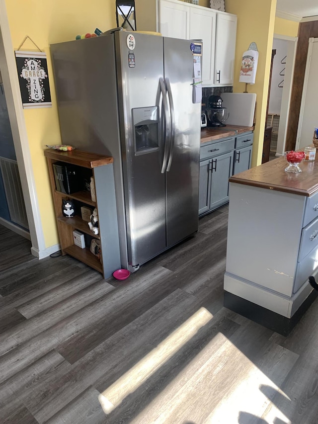 kitchen with visible vents, butcher block countertops, dark wood-style floors, white cabinetry, and stainless steel fridge with ice dispenser