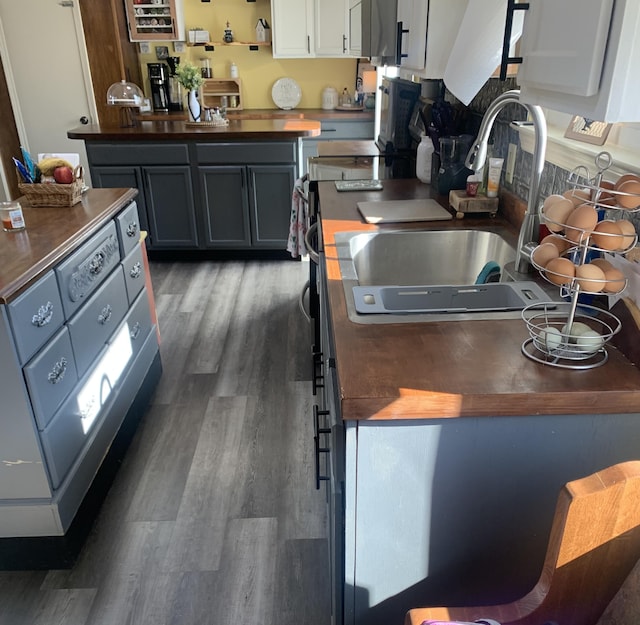 kitchen featuring a sink, wood counters, and wood finished floors