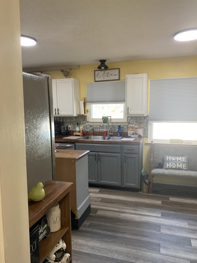 kitchen with a sink, tasteful backsplash, a healthy amount of sunlight, and gray cabinets