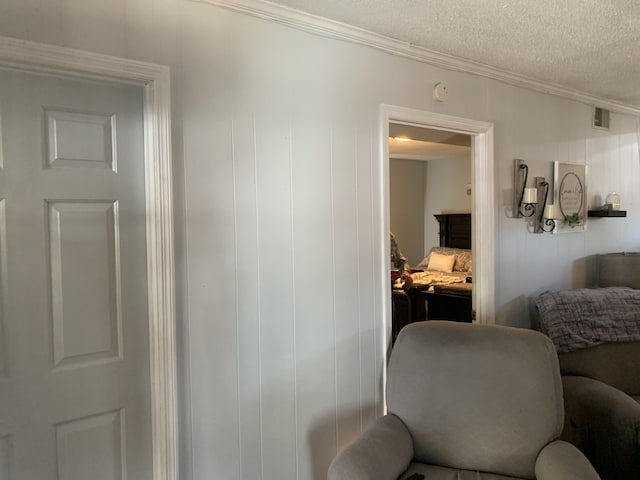 interior space featuring visible vents, a textured ceiling, and ornamental molding