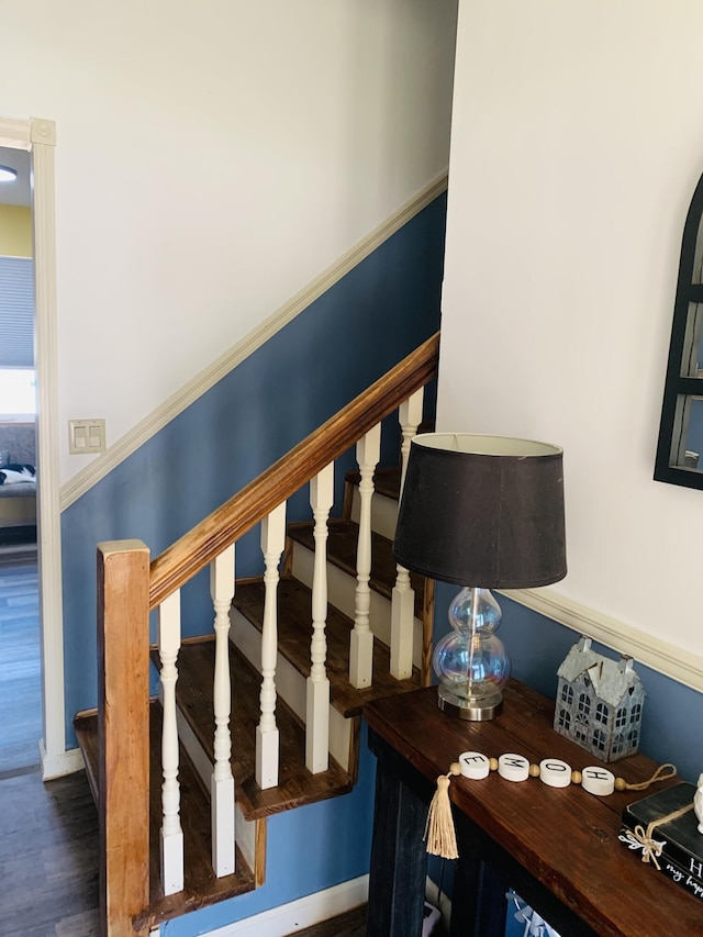 staircase with wood finished floors and baseboards