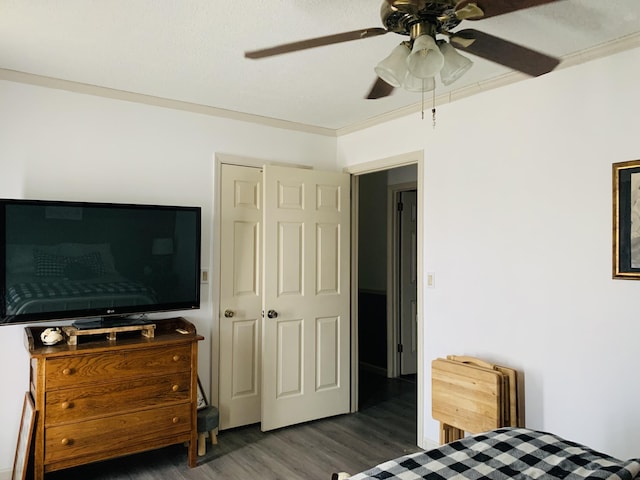 bedroom with crown molding, wood finished floors, and ceiling fan