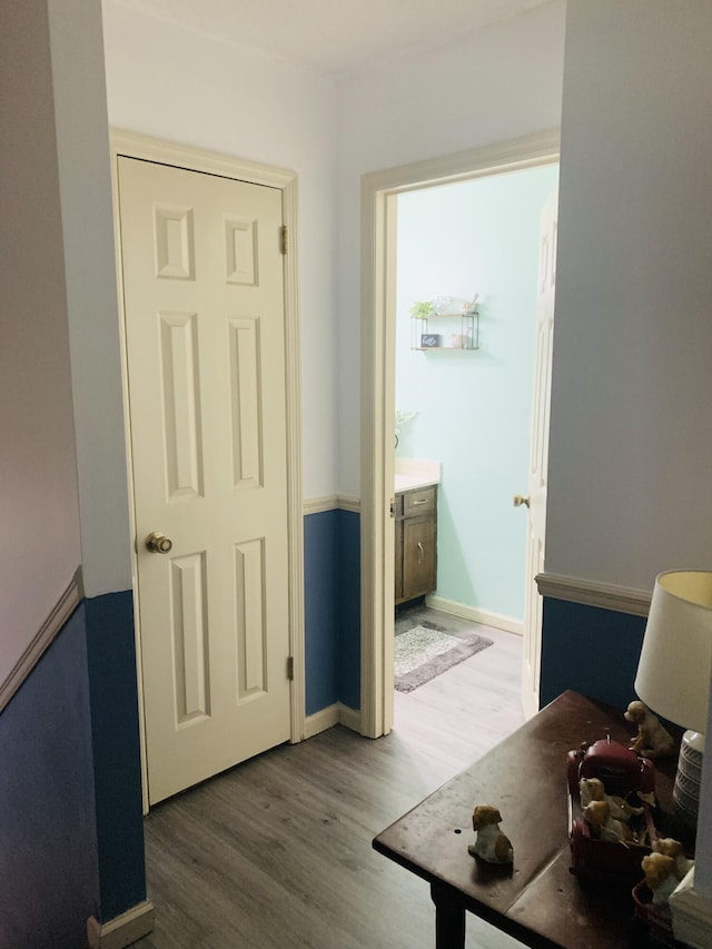 corridor with baseboards and wood finished floors