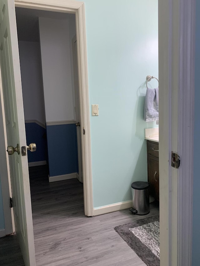 bathroom featuring vanity, baseboards, and wood finished floors