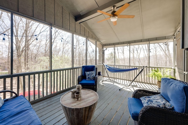 sunroom / solarium featuring a ceiling fan and vaulted ceiling with beams