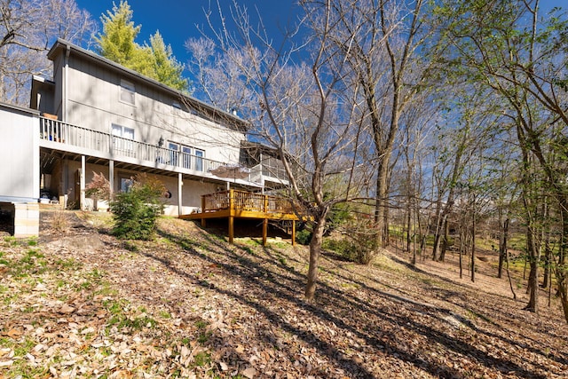 rear view of house featuring a wooden deck