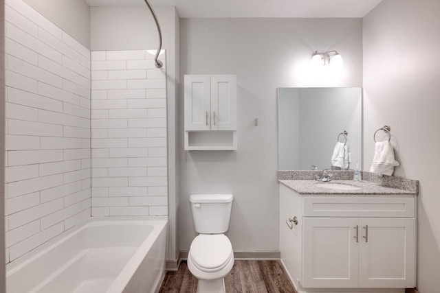 bathroom with baseboards, toilet, wood finished floors, tub / shower combination, and vanity