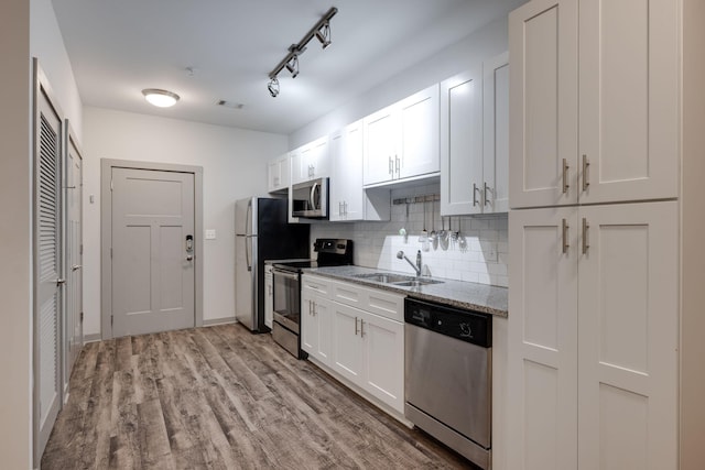 kitchen with stainless steel appliances, tasteful backsplash, visible vents, white cabinets, and a sink