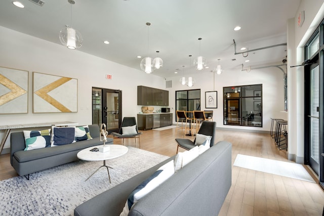 living area with light wood finished floors, visible vents, and recessed lighting