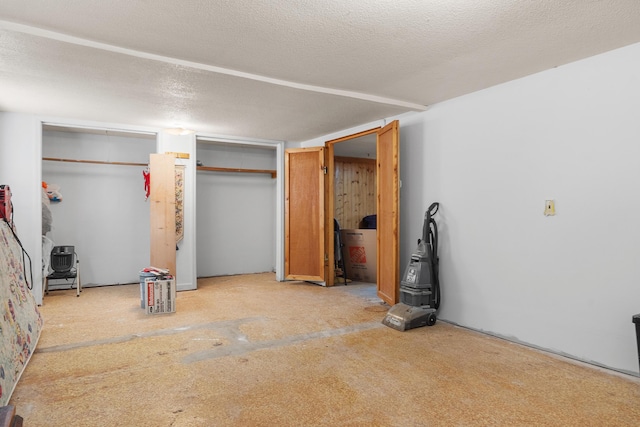 unfurnished bedroom with a textured ceiling and two closets