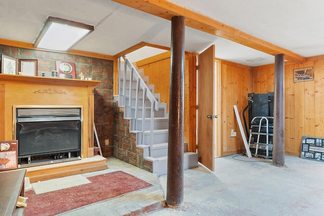 finished below grade area with stairway, a fireplace, and wooden walls