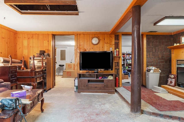 living area featuring wood walls and concrete flooring