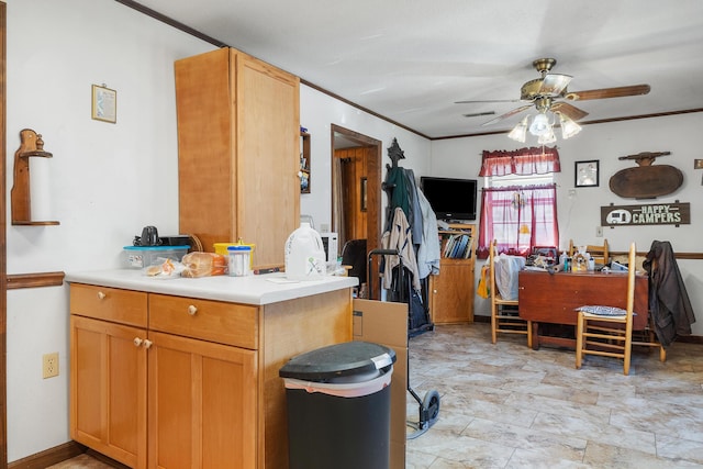 kitchen featuring ceiling fan, light countertops, and crown molding