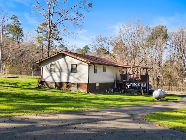 view of side of home featuring a lawn and a wooden deck