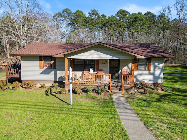 ranch-style house with roof with shingles, a porch, and a front lawn