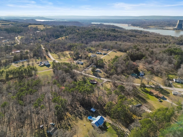 birds eye view of property featuring a water view and a view of trees