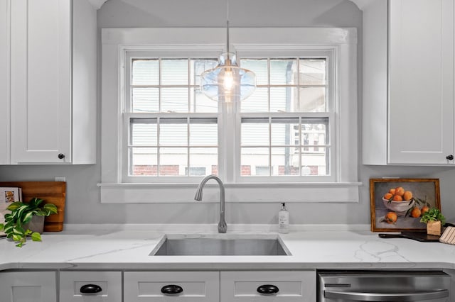 kitchen featuring dishwasher, white cabinetry, a wealth of natural light, and a sink